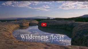 Screenshot of "Wilderness Areas" appearing over a pond in geologic rock formations