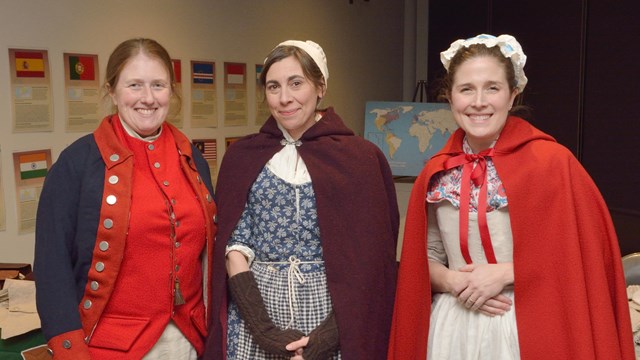 Three people in colonial costumes.