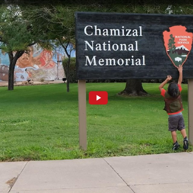 Video screenshot of a kid touching a sign for Chamizal National Memorial