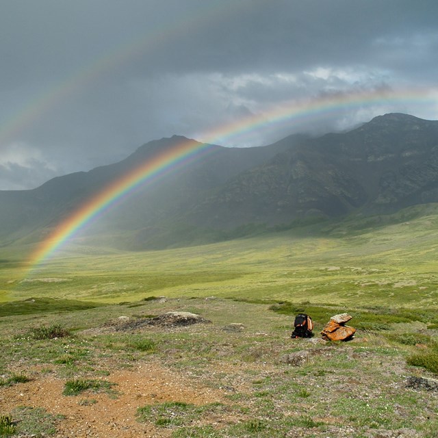 Rainbow in a valley near mountains