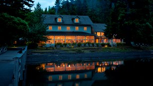 Lake Crescent Lodge lights reflect upon the lake in evening.