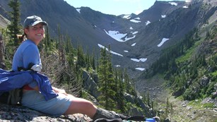 Hiker rests along a mountain trail.