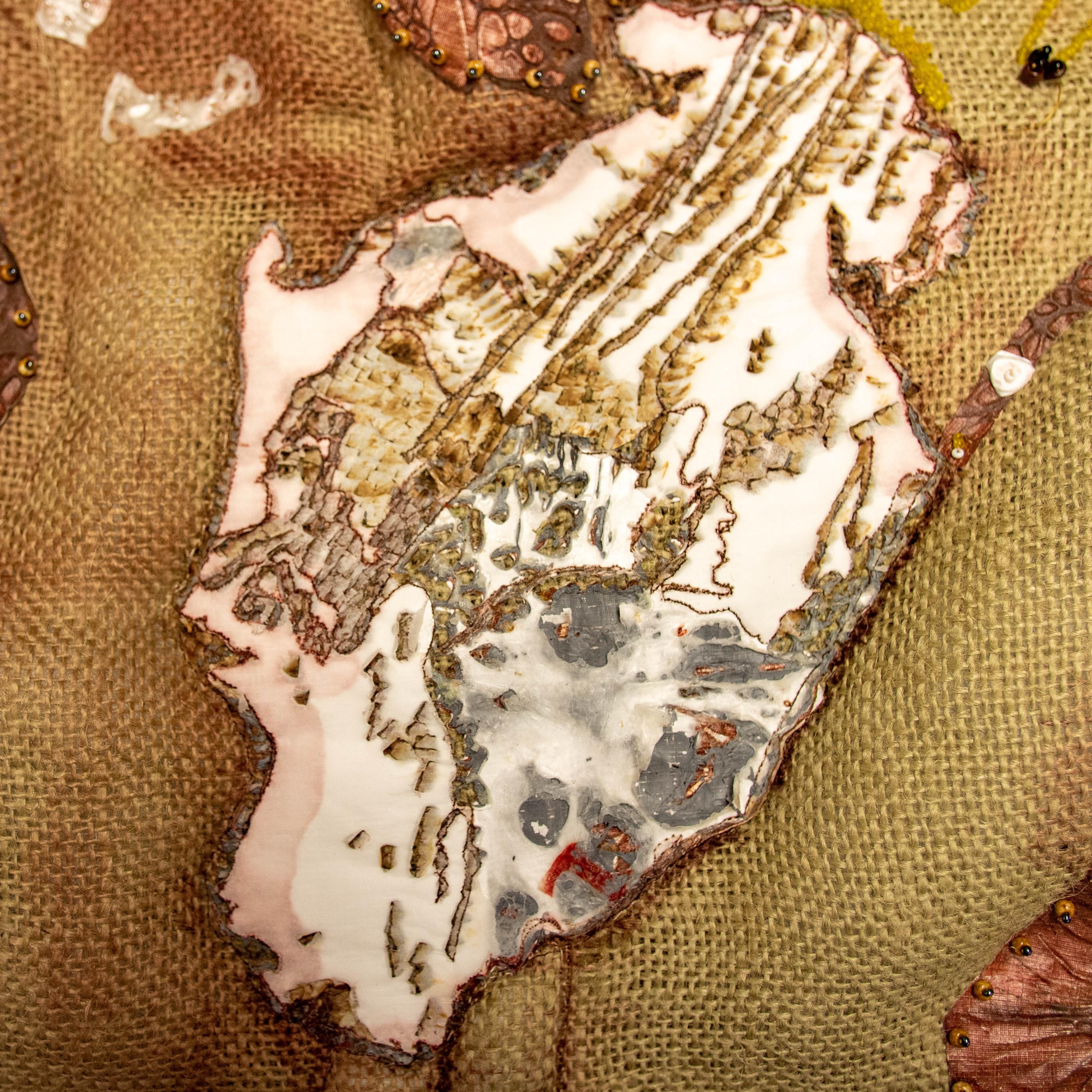An abstract art quilt representation of a mountain glacier in burlap, beading, plastic, and tyvec.