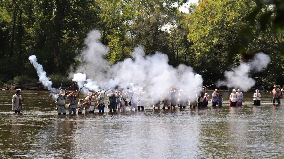 "Overmountain men" firing muskets during a river crossing
