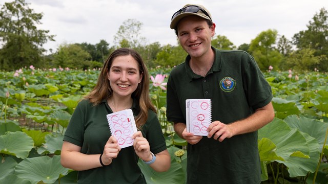Two National Park Service interns show their passport stamp collection at Kenilworth Aquatic Gardens
