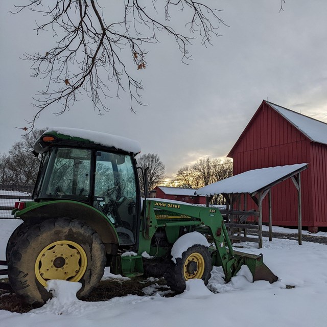 A big green tractor on a snowy day