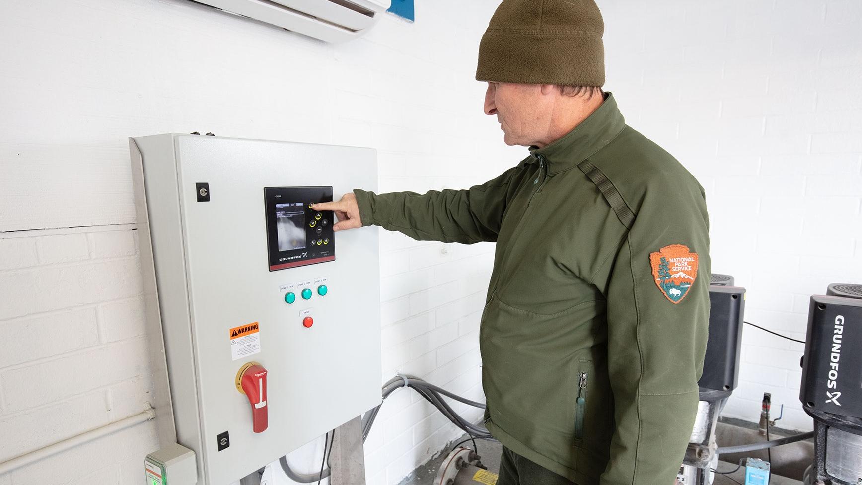 A person examining equipment in a mechanical room 