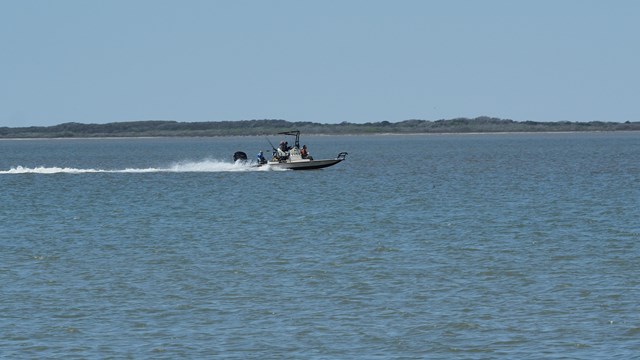 A motorboat speeds across the water. 