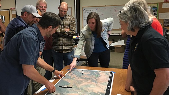 Small group standing around a map on a table