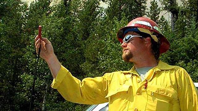 Fire behavior analyst Dave Whitmer takes readings during fire in Glacier National Park in 2003