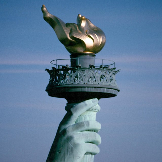 Photo of the hand of the Statue of Liberty holding the torch
