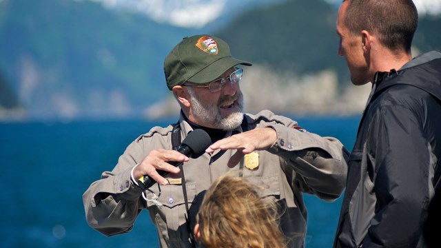 Interpretive ranger talks with visitors onboard a boat.