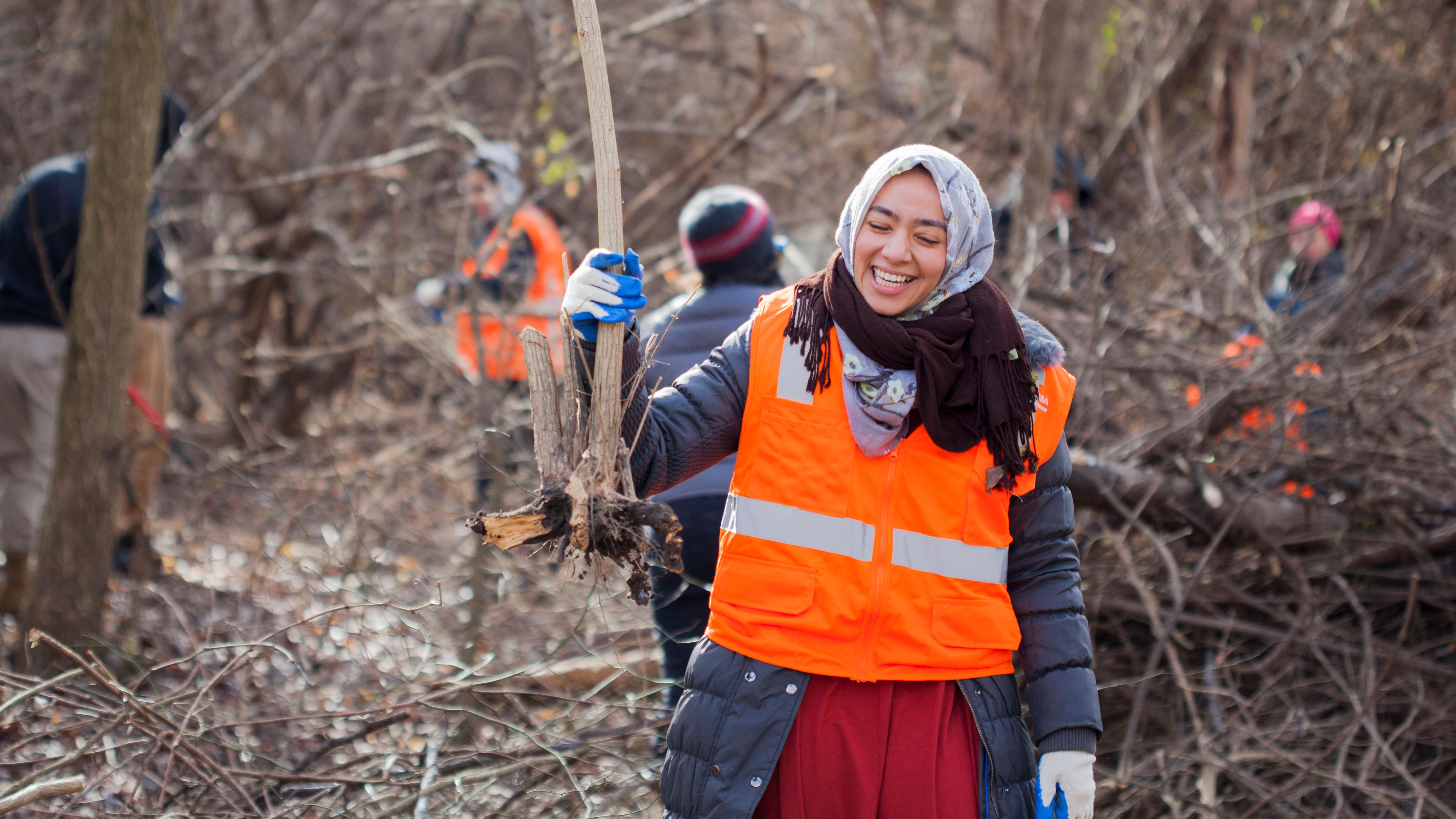 Two volunteers posing with a piece of trash they've picked up.