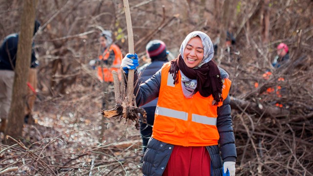 Two volunteers posing with a piece of trash they've picked up.