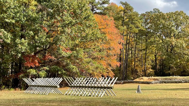 Chevaux de Frise in the foreground and multicolored trees in the backfround.