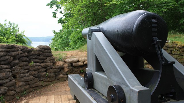 A Columbiad cannon is mounted on a high bluff overlooking the James River.