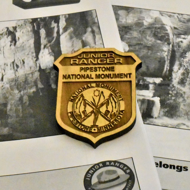 A Jr. Ranger badges on top of Jr. Ranger booklets