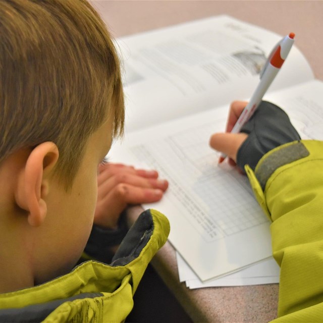 A boy writing in a book