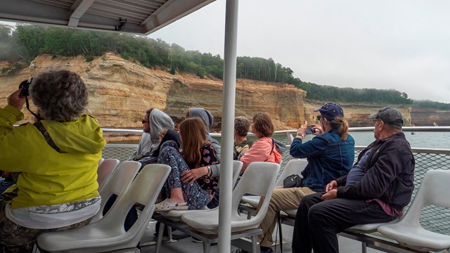 A group of people take photos from a guided boat tour