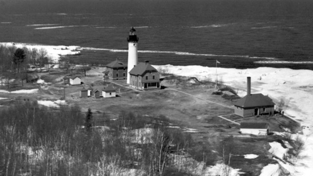 A historic aerial photo of the Au Sable Light Station in winter.