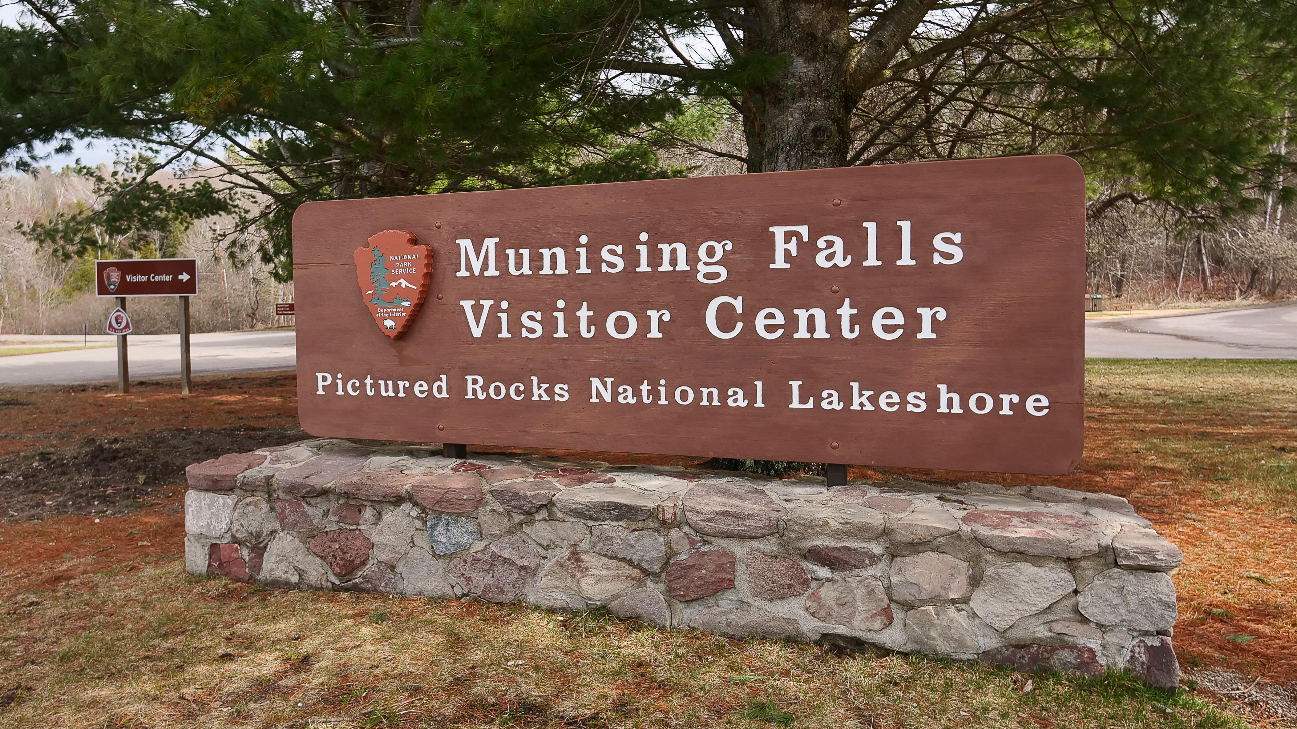 A brown sign reading "Munising Falls Visitor Center".