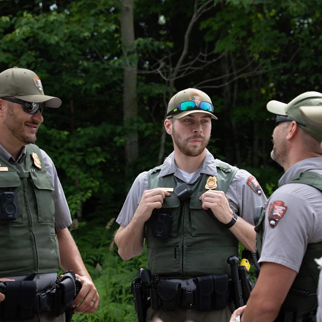 Four rangers stand in a group talking to one another