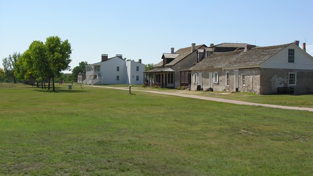 Historic log cabin in a grassy setting.