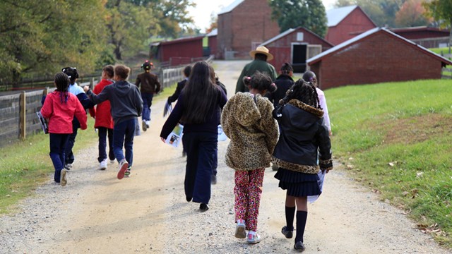 A group of people on a trail led by a park ranger.