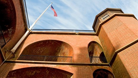 Flag flying over masonry arches of Fort Point
