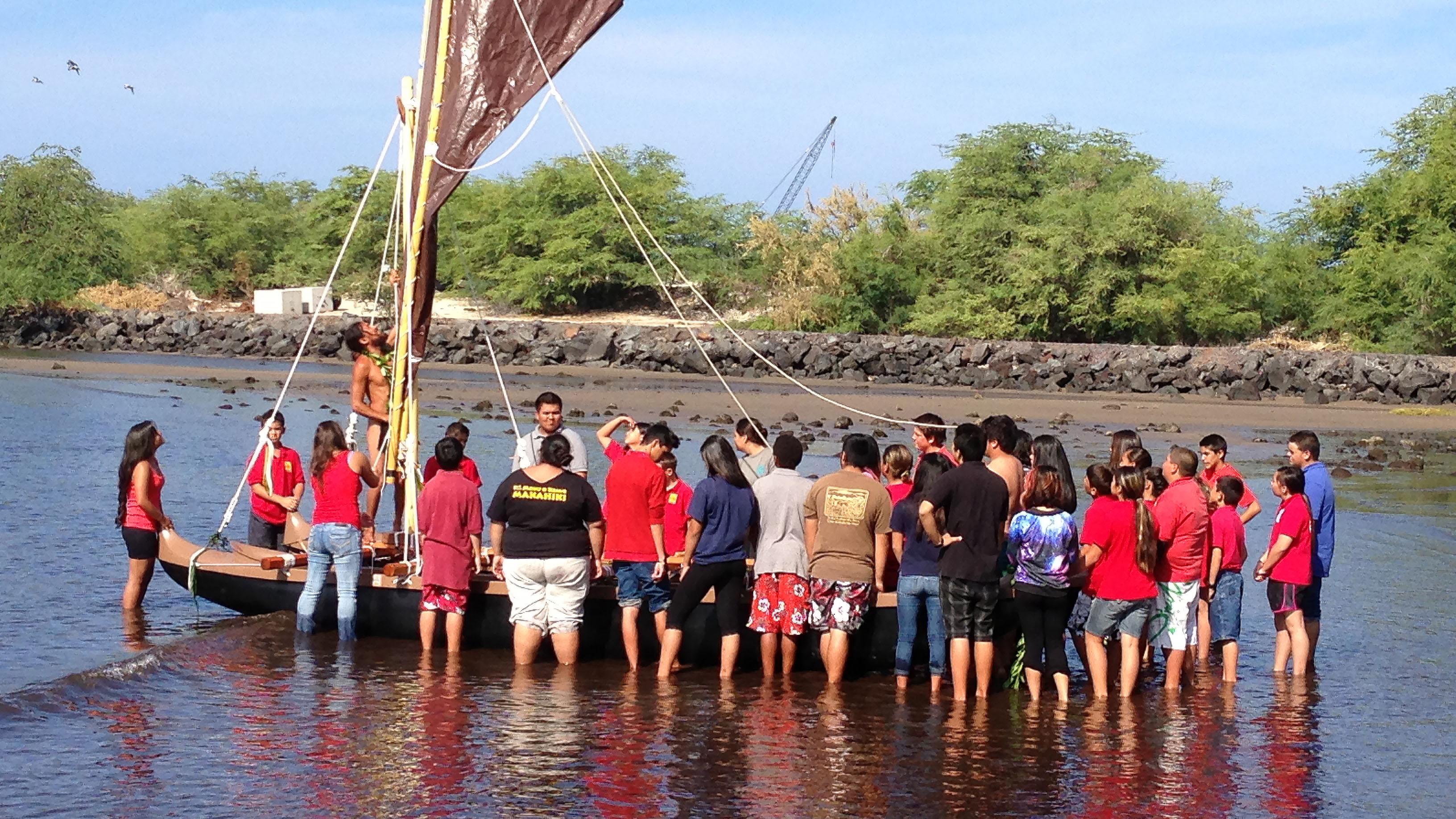 Group of kids getting a traditional canoe ready for sailing