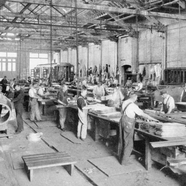 A photo of shop workers at their benches.