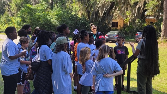 A ranger speaks to a group of children.