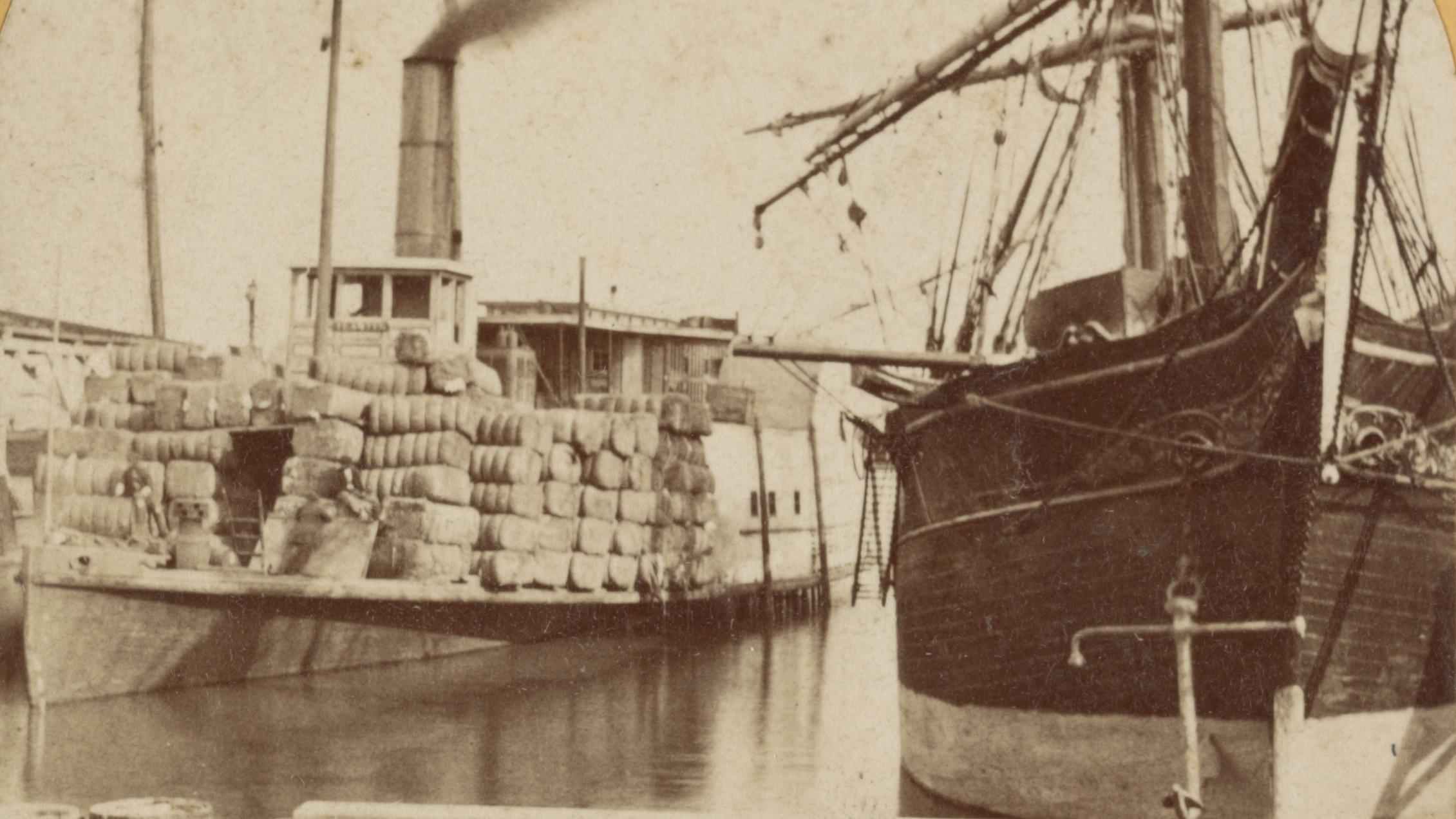 A steamer boat in a marina next to a sailing vessel.