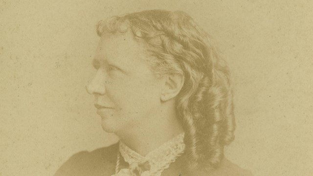 The portrait of Ellen Murray in a dark dress with lacy shirt and curled hair.