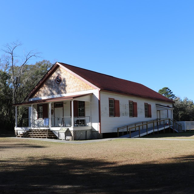 A white single-story building with a front porch and ramp.