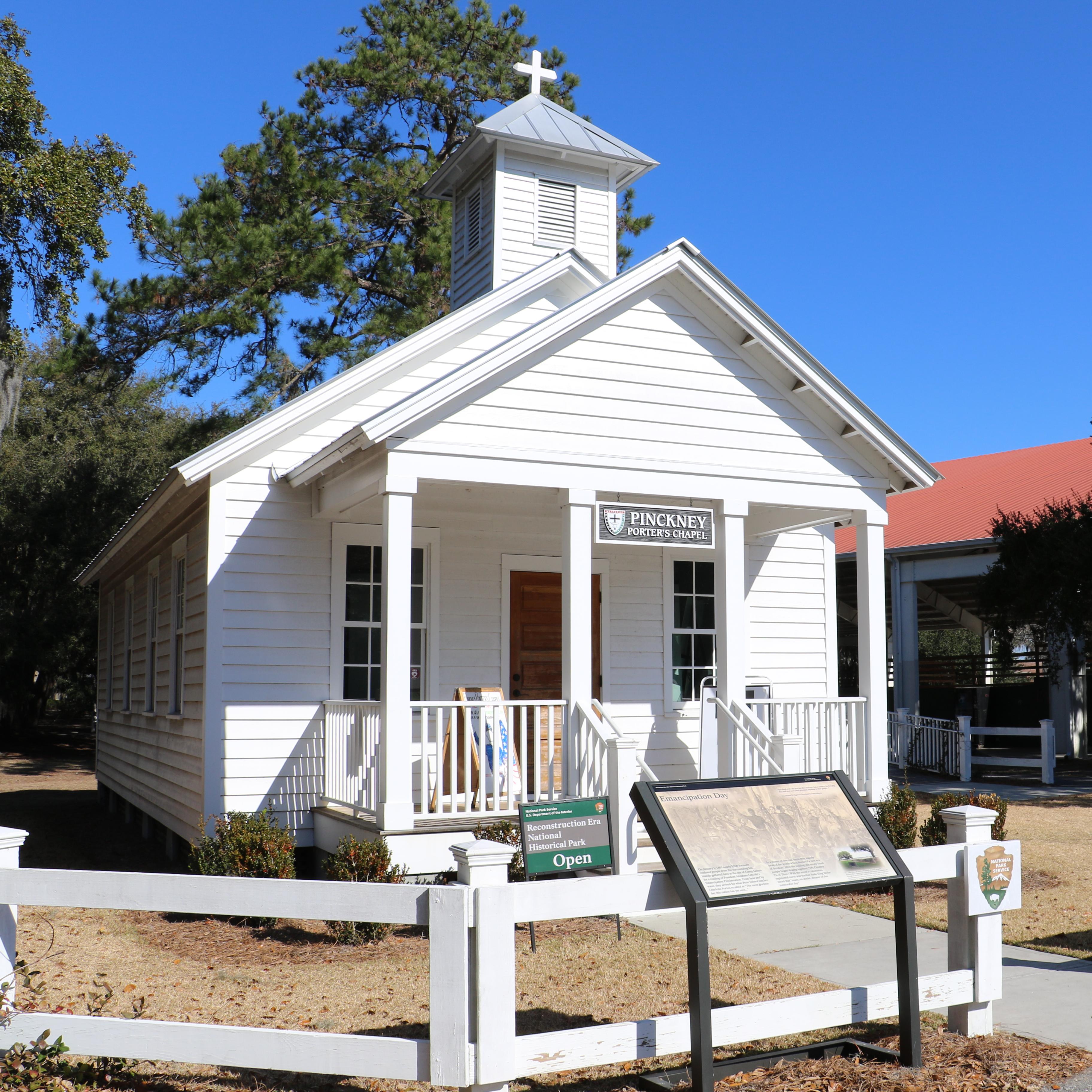 A small white chapel with a tower and a front porch.