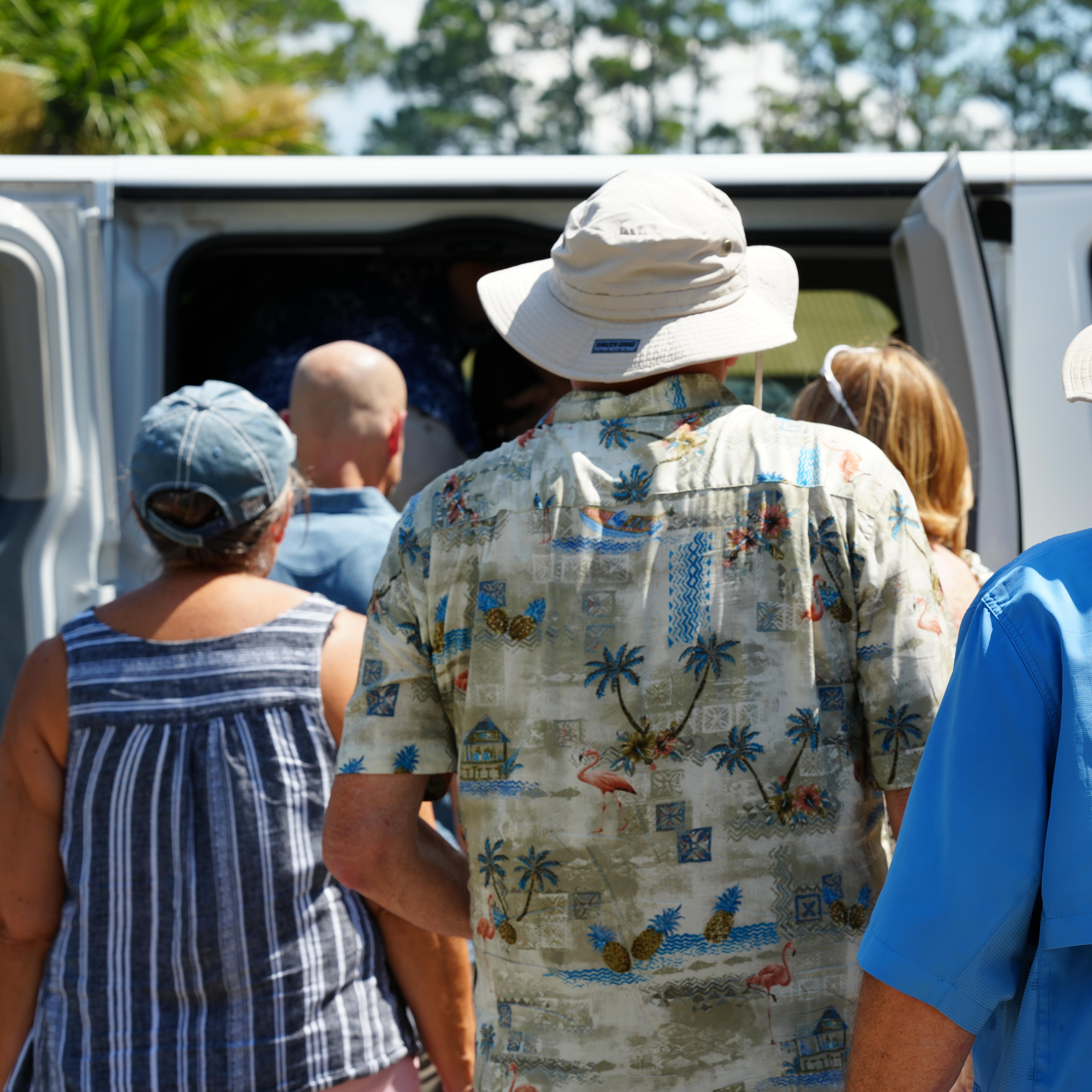 A group of people walk towards a van.