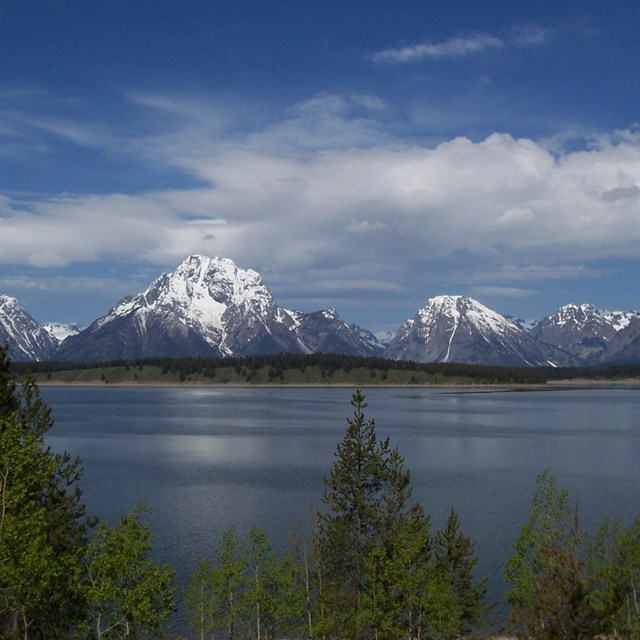 Mount Moran with snow and Jackson Lake with clouds.