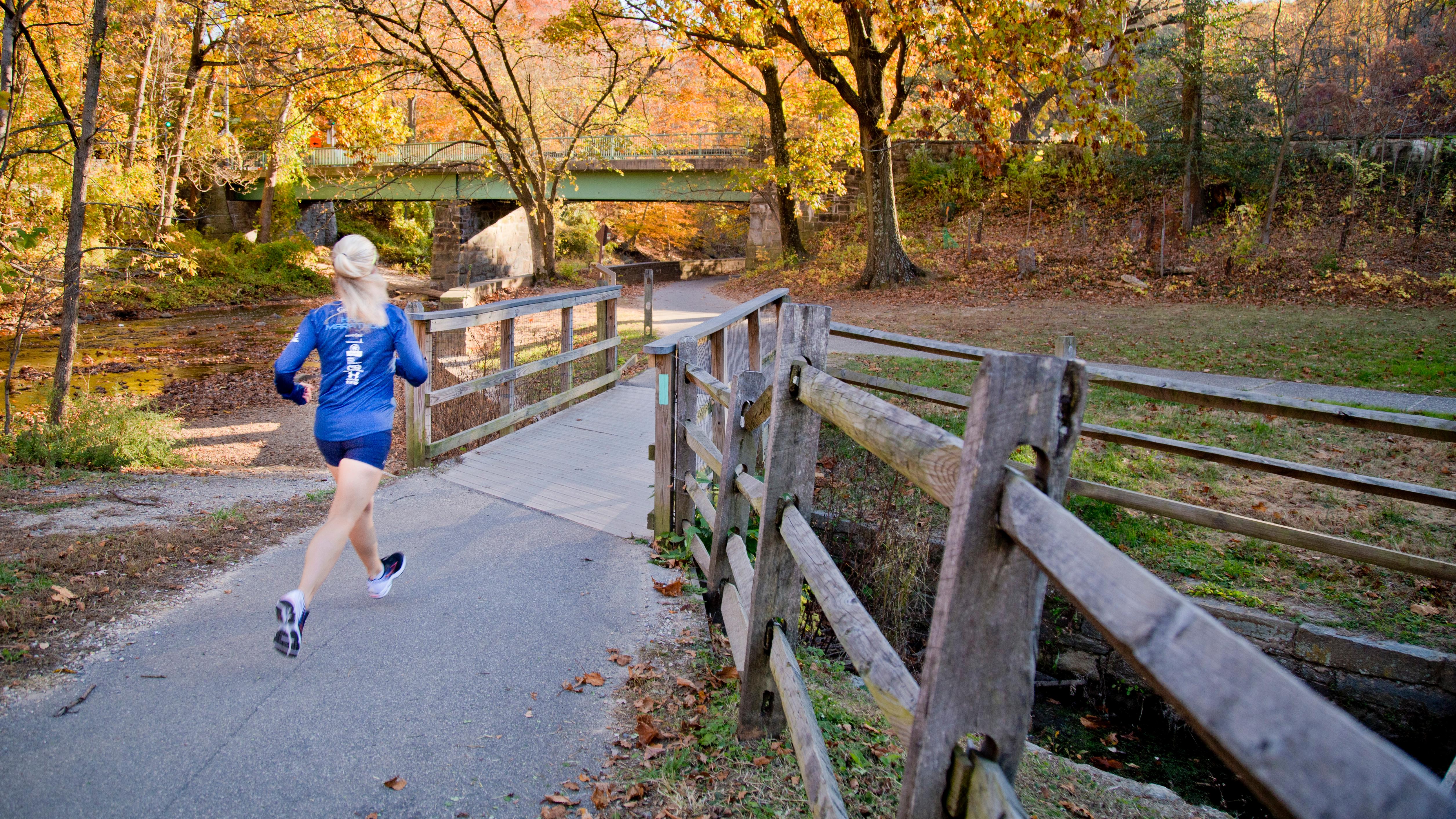 A woman runs on a trail in Rock Creek Park. 