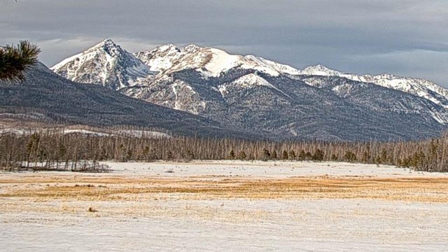 Webcam image from the Kawuneeche Valley with mountain peaks covered with recent snow