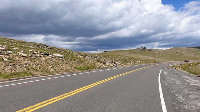 View of a section of Trail Ridge Road on a summer day. The road is paved and free of snow.