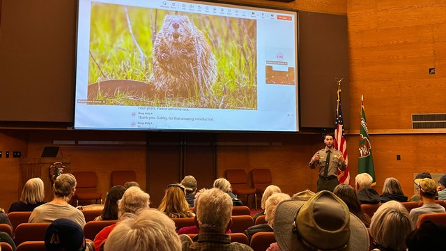 A park ranger is sharing a program inside Beaver Meadows Visitor Center