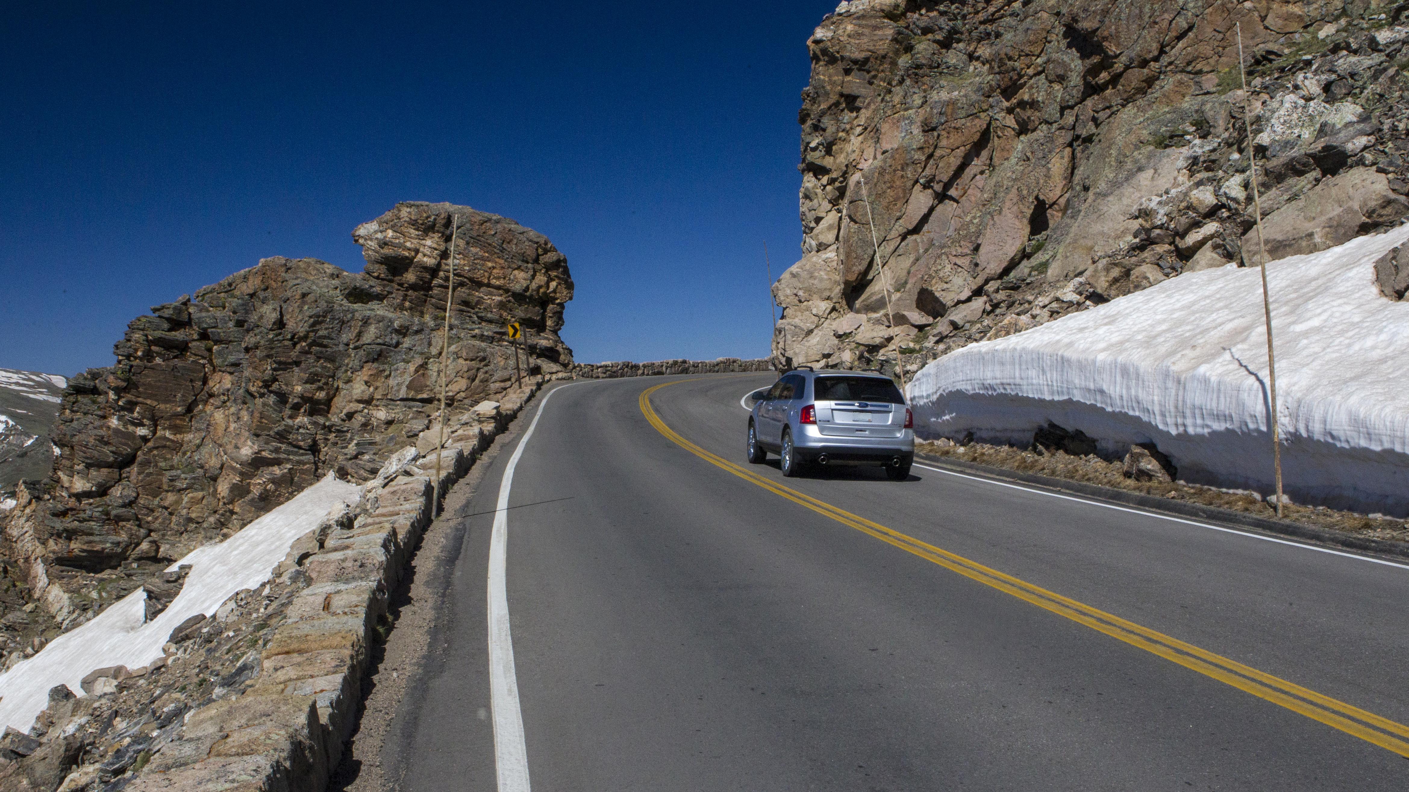 A vehicle is driving on Trail Ridge Road near Rock Cut