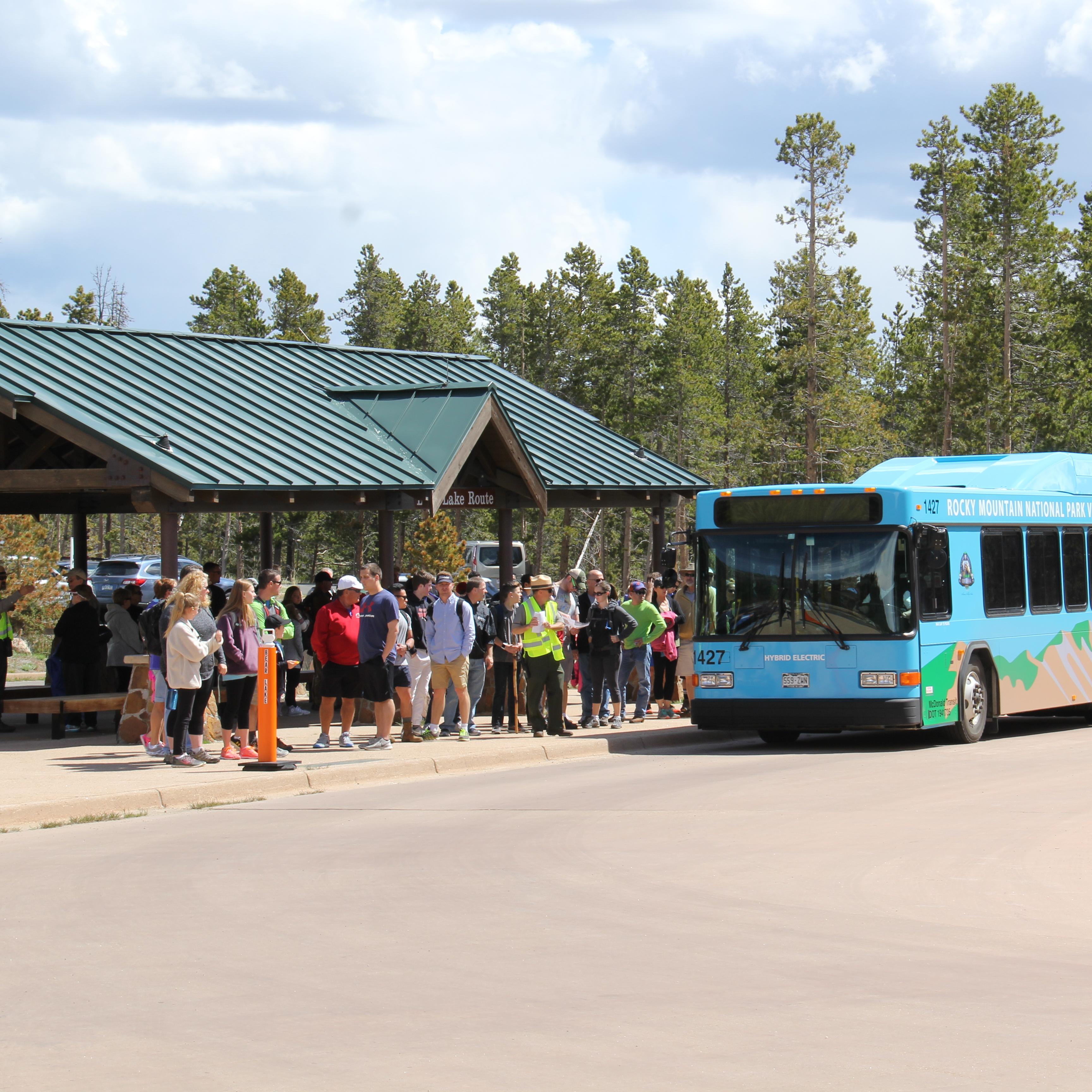 A long line of people waiting for a shuttle bus.