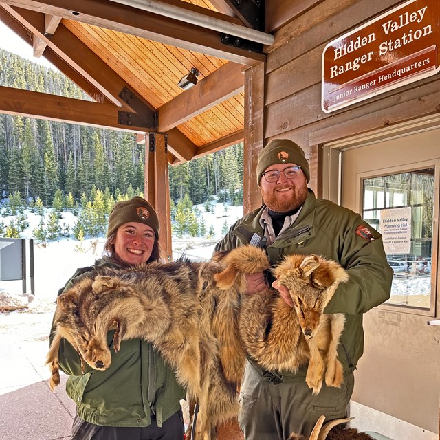 Two park rangers are staffing a booth at Hidden Valley in winter