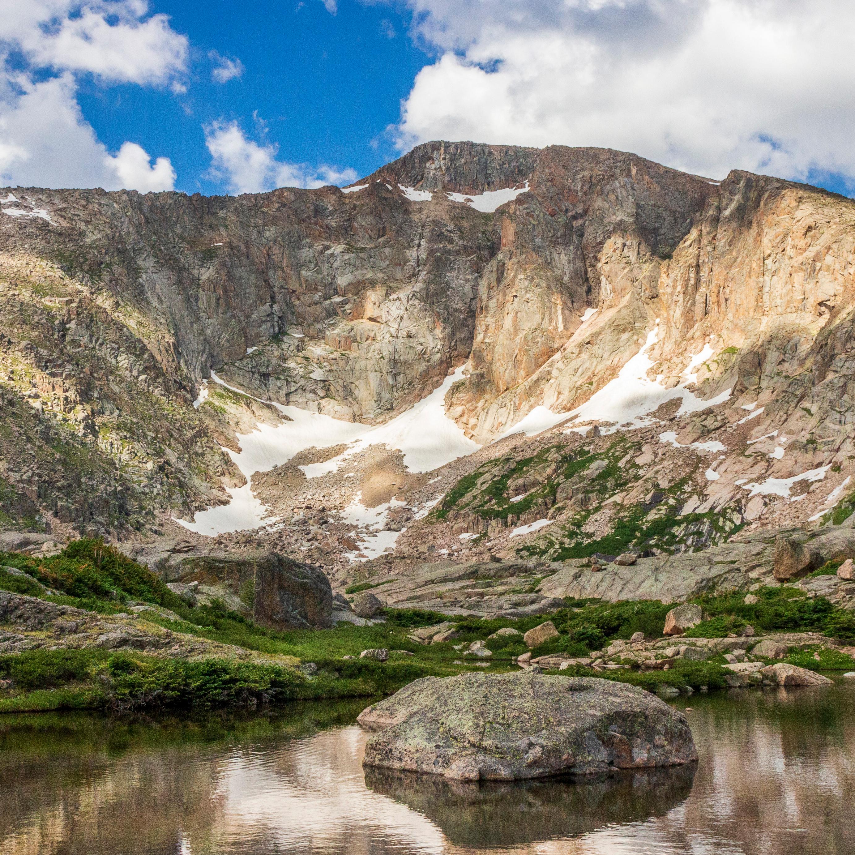 Image of alpine lake surrounded by mountain peaks in summer