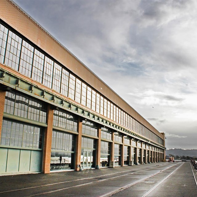 A large rectangular building with windows from top to bottom. Waterfront view. 
