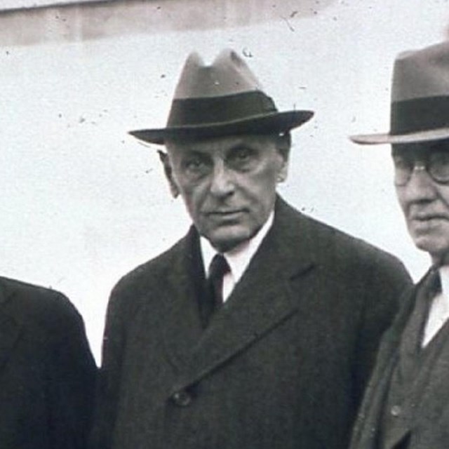 Black and white photo of a man in suit and hat