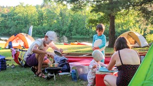 A family cooks outdoors at their campsite,