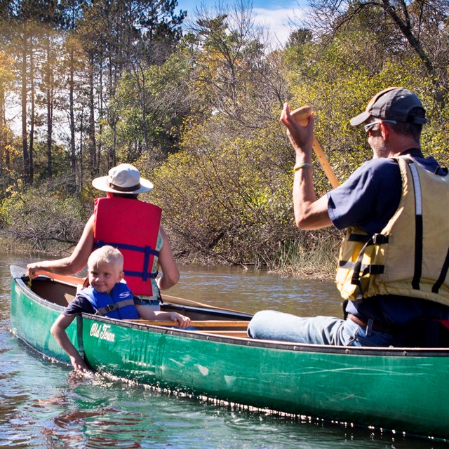 A family paddles in a canoe.